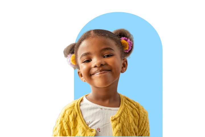 Little African American Girl with space buns and a yellow sweater with a light blue column behind her